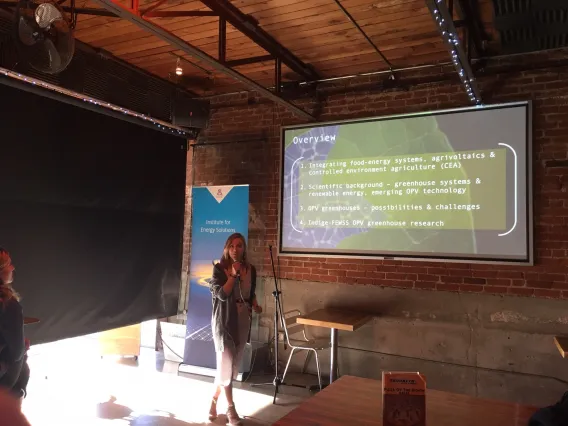 Bekah Waller giving an Energy Talk with a presentation projected behind her