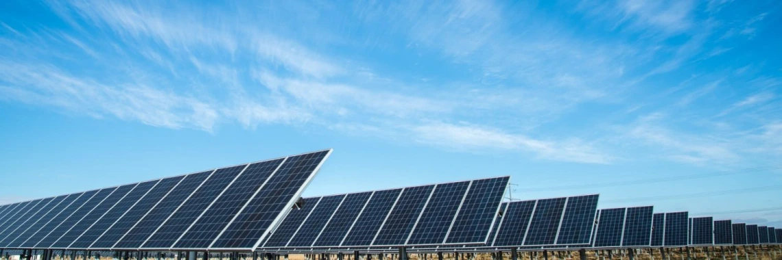 Solar panels with a mostly clear blue sky overhead