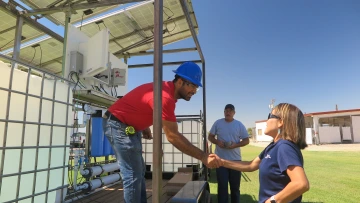 Dr. Karletta Chief shaking hands with a construction worker in a hard hat.